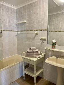 3ColoursBlue Guest House في خليج موسيل: حمام مع حوض ومغسلة وحوض استحمام