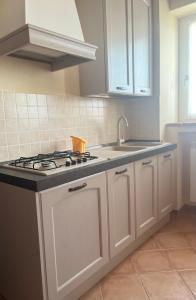 a kitchen with white cabinets and a stove top oven at Ca' dal Bertu - Cascina in Monferrato in Rosignano Monferrato