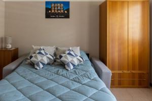 a bedroom with a blue bed with two pillows at Casa vacanze- Debra in Aosta