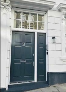 a blue door of a house with a window at Gorgeous split level Belsize Park Apartment in London