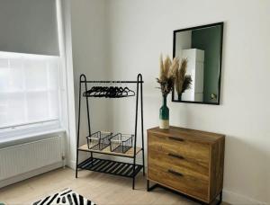 a room with a mirror and a wooden dresser at Gorgeous split level Belsize Park Apartment in London