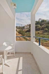 a balcony with a table and chairs and a view at Venetia Studios in Karpathos