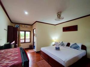 Phamarn View Guesthouse في Ban Nahin-Nai: غرفة نوم بسرير كبير وغرفة بسرير ومقهى