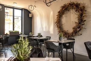 un restaurant avec des tables, des chaises et une couronne sur le mur dans l'établissement MORE Hotel, à Liepāja