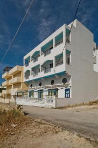 een wit gebouw met balkons aan de zijkant bij Venetia Studios in Karpathos