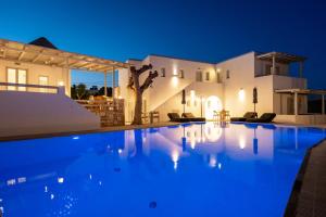 una villa con piscina di notte di Anemomylos Residence a Naoussa