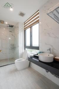 uma casa de banho com um WC, um lavatório e um chuveiro em Sakura Homestay Cao cấp T4 em Gia Lâm Pho