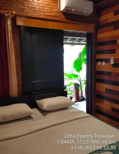 a bedroom with a bed with a window and a bed sidx sidx at GRHA PAWITRA TROWULAN in Trowulan