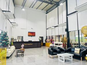 a lobby with black leather furniture and a christmas tree at Baan Plaifah Khao Yai Hotel in Khao Yai