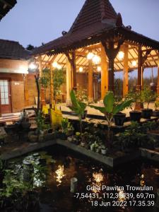 GRHA PAWITRA TROWULAN في Trowulan: حديقة فيها بركة امام شرفة