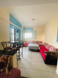 ein Wohnzimmer mit einem roten Sofa und einem Tisch in der Unterkunft Superbe maison à M'diq in Mʼdik