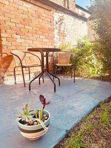 uma mesa e cadeiras e um vaso de plantas num pátio em Traditional English House em Derby