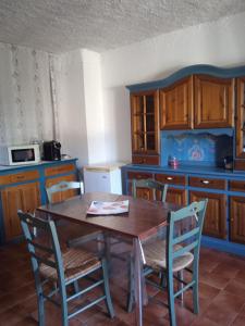 a kitchen with a wooden table and chairs at Casa Martine in Orosei
