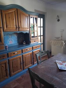 a kitchen with wooden cabinets and a table at Casa Martine in Orosei