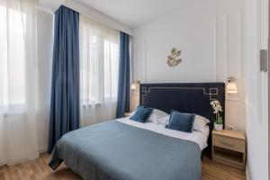 a bedroom with a large bed with blue curtains at Annex building of Art Hotel in Split