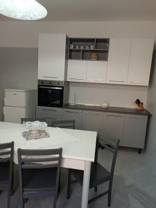 une cuisine blanche avec une table et des chaises blanches dans l'établissement A CASA MIA, à Savone