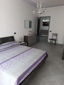 une chambre avec un grand lit et un lustre dans l'établissement A CASA MIA, à Savone