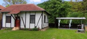 a small white house with a gazebo in a yard at Глинената къща в Дълги Дел in Dŭlgi Del