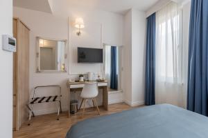 a bedroom with a bed and a desk and a tv at Annex building of Art Hotel in Split