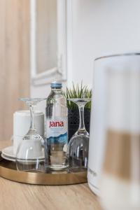 duas garrafas e copos numa bandeja numa mesa em Annex building of Art Hotel em Split