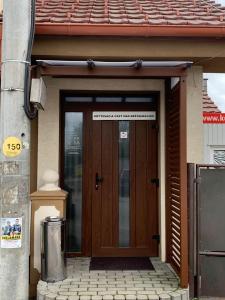 uma porta de madeira de uma casa com um sinal em Reštaurácia-penzión ALTANA em Ludanice