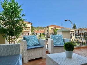 balkon z wiklinowymi krzesłami i stołem z rośliną w obiekcie Jennas-Grecale Apartment w mieście Àrbatax