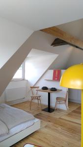ein Schlafzimmer mit einem Bett und einem Tisch im Dachgeschoss in der Unterkunft steenkampstudios LOFT in Hamburg