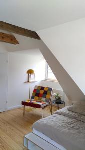 ein Schlafzimmer mit einem Bett und einem Stuhl in einem Zimmer in der Unterkunft steenkampstudios LOFT in Hamburg