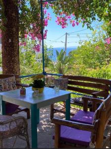 a blue table and chairs with a tree and flowers at Garden House in Hora Sfakion