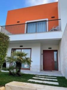 an orange and white house with a red door at Casa da alegria in Vau