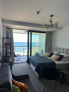 a bedroom with a bed and a view of the ocean at Apartament 409 z Widokiem na Morze - Seaside in Kołobrzeg