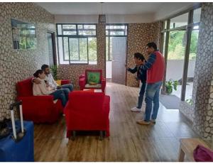 um grupo de pessoas numa sala de estar a jogar um jogo de vídeo em Basudhalaya Home Stay, Darjeeling em Darjeeling
