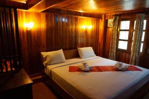 a bedroom with a bed with two teddy bears on it at Phonepraseuth Guesthouse in Luang Prabang
