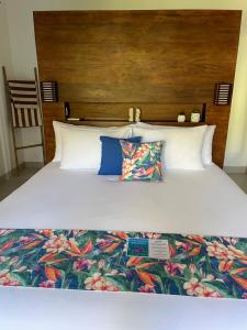 1 cama con sábanas blancas y almohadas azules en Kaien Villas Gili Air, en Gili Air