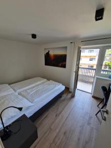 ein Schlafzimmer mit einem Bett und einem großen Fenster in der Unterkunft Anna & Paul Appartements in Söll