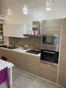 una cocina con estufa y microondas en Recente costruzione, centrale, tutti i comfort, en Pozzallo
