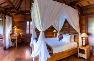 a bedroom with a canopy bed in a room at Villa Neyang in Ubud