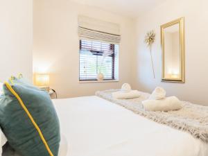 1 dormitorio con 1 cama blanca y 2 almohadas en Bwthyn Bach, en Dyffryn