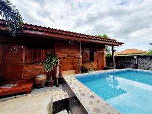 - une piscine en face d'une maison dans l'établissement Perfect Resort & motorbikes for rent Sukhothai, à Sukhothaï