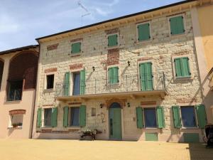 un edificio con puertas verdes y balcón en Ca' dal Bertu - Cascina in Monferrato en Rosignano Monferrato