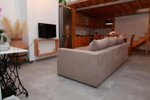 ein Wohnzimmer mit einem Sofa und einer Küche in der Unterkunft Cane’s Family Guest House in Plomari