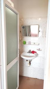 ein Bad mit einem Waschbecken und einem Spiegel in der Unterkunft NHÀ NGHỈ DU LỊCH MINH LONG - Quảng Trường in Cao Bằng