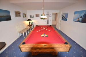 uma mesa de pingue-pongue numa sala de estar com piscina em Haus-Neumann em Westerland