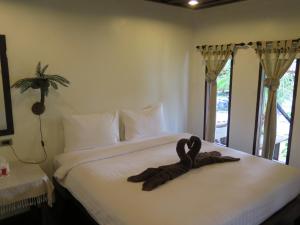 un animal de peluche está sentado en una cama en V-View Beach Resort en Baan Tai