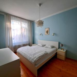 - une chambre avec un lit blanc et un mur bleu dans l'établissement Cozy & Stylish apartment in the heart of Sofia, à Sofia