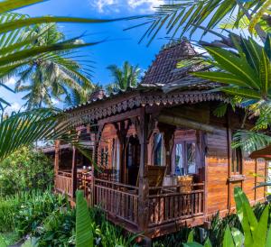 a house in the jungle with palm trees at Villa Neyang in Ubud