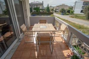 d'une terrasse avec une table et des chaises sur un balcon. dans l'établissement Maison Elisa, à Alexandroúpolis
