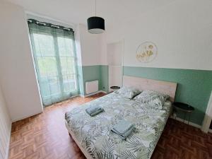 een slaapkamer met een bed met handdoeken erop bij Le Colibri - Appartement 4 à 6 couchages avec terrasse in Allemont