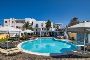 a pool at a hotel with chairs and umbrellas at Kalimera Hotel in Akrotiri