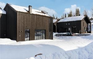 a building covered in snow next to a pile of snow at Amazing Home In Slen With Wifi in Stöten